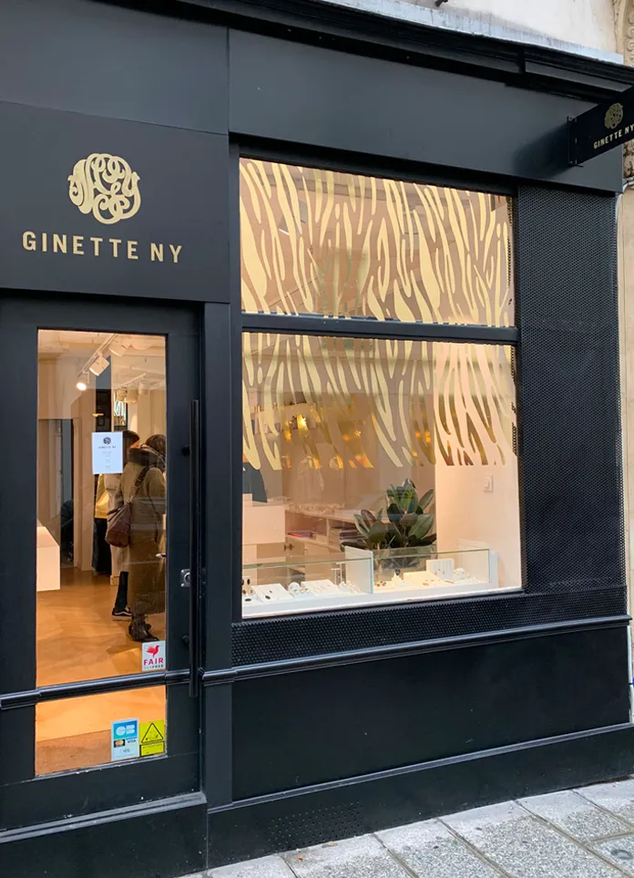 Vitrophanie de la boutique Ginette NY à Paris avec un design tigré en dorure pour la nouvelle collection